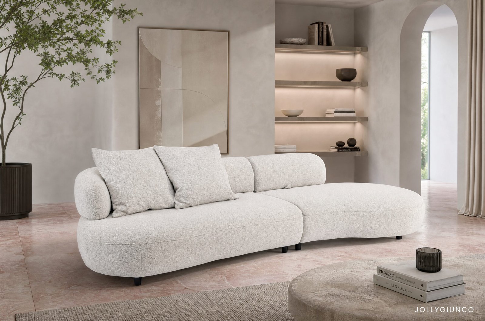 DIVANO C-C AFRODITE10 - JOLLYGIUNCO Neutral-toned living room with a plush beige sectional, potted tree on the left, and built-in lit shelves on the right.