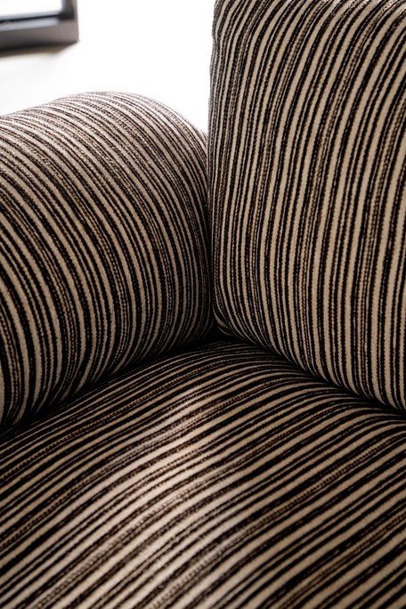 POLTRONA MORVANA RIGHE SAGE7 - JOLLYGIUNCO Close-up of beige and black striped upholstery on a sofa cushion in a cozy living room setting.