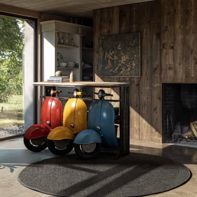 Vespa scooter collezione colorata in interni rustici, stile vintage con pavimento in legno e illuminazione naturale.